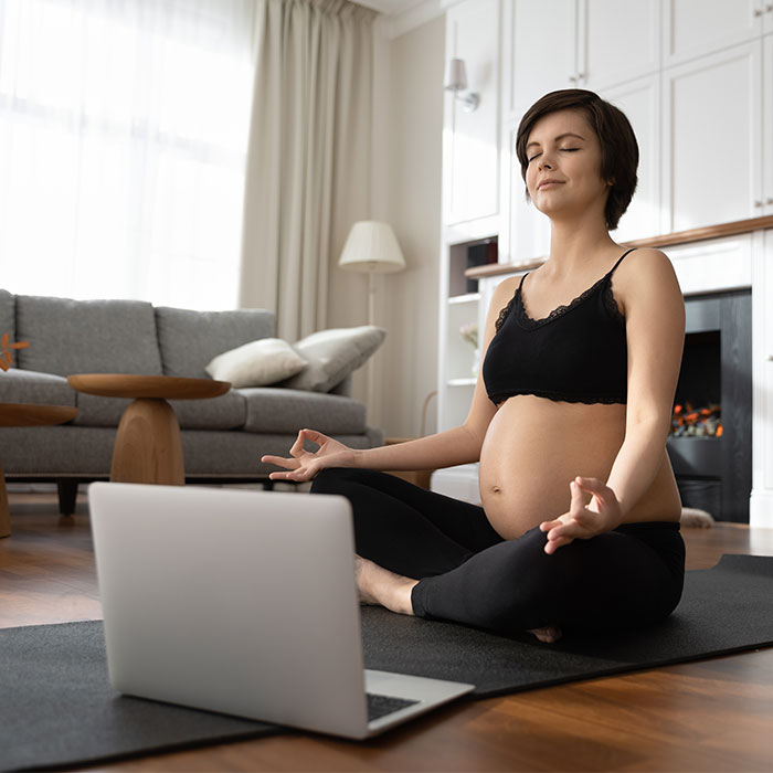 Pregnant woman meditating during a virtual session