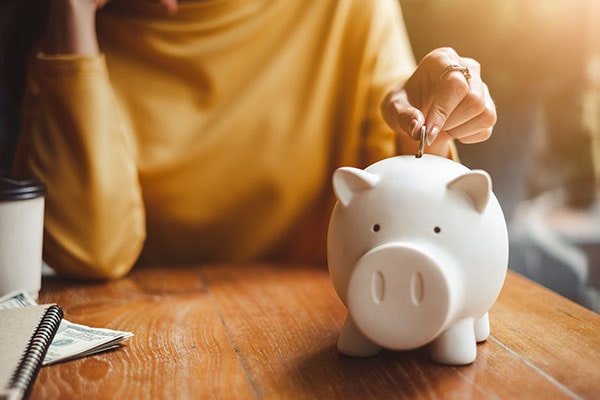 Woman putting money into a piggybank